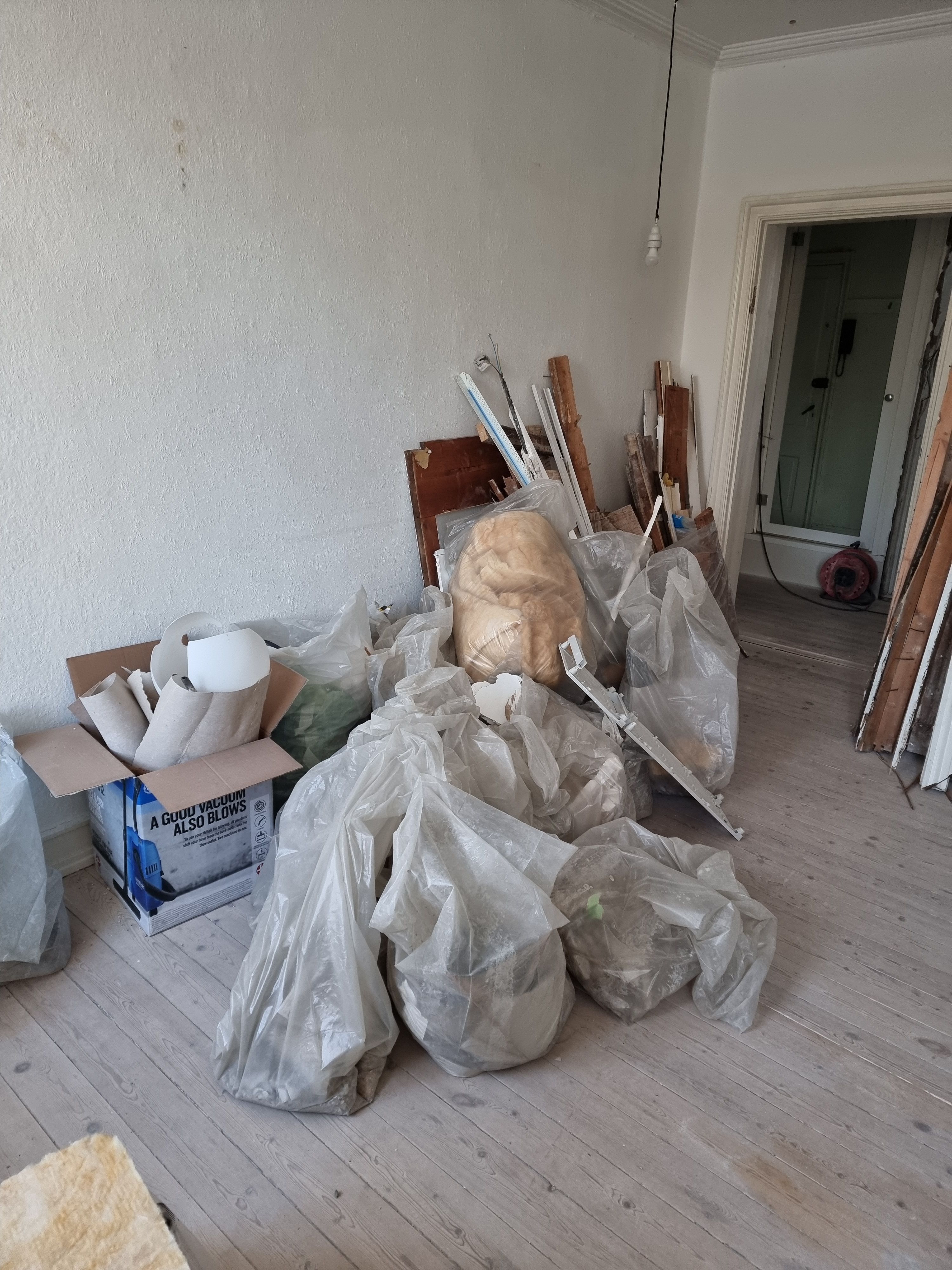 Fjernelse af byggeaffald efter nedrivning af væg i lejlighed