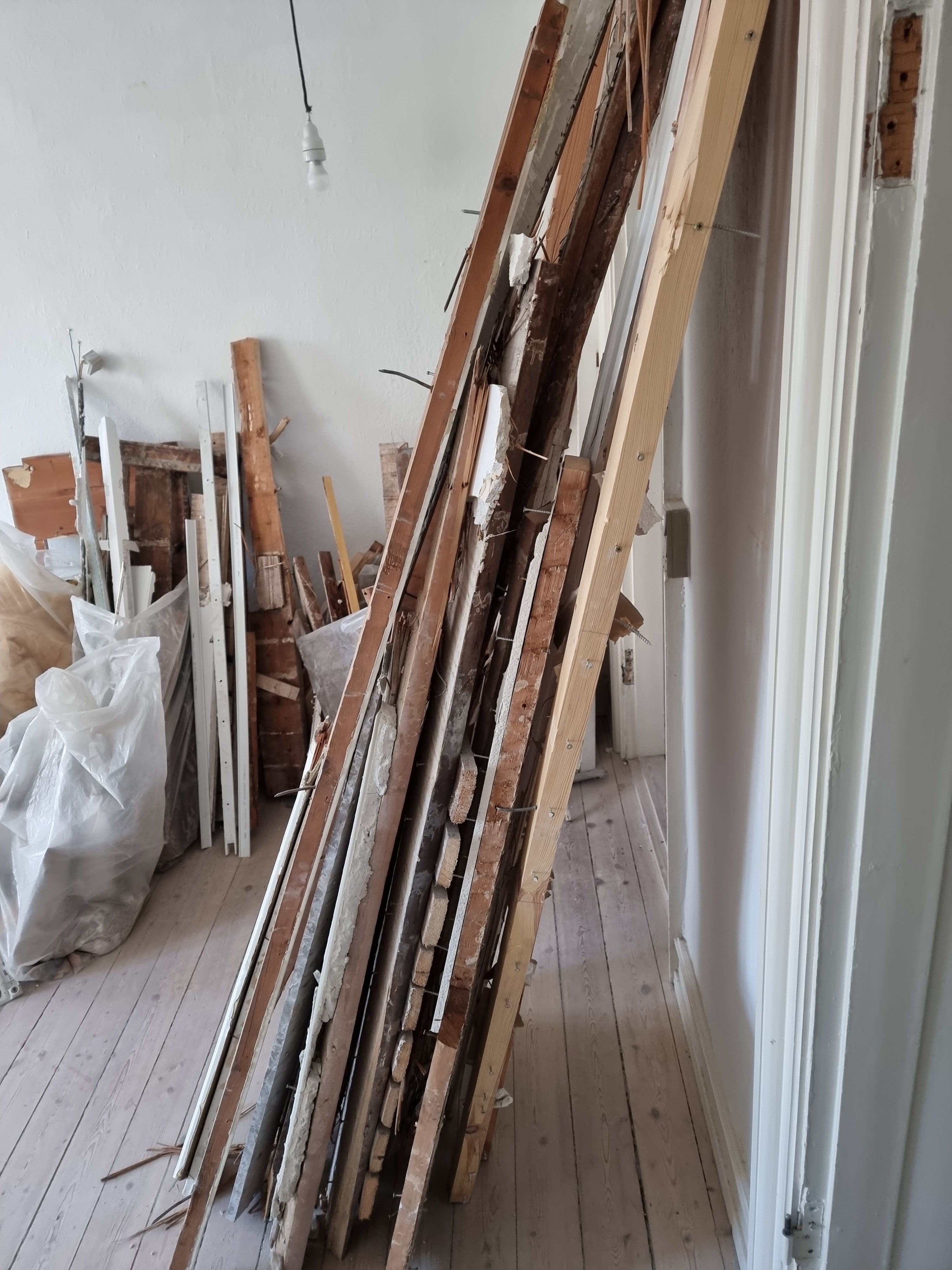 Fjernelse af byggeaffald efter nedrivning af væg i lejlighed