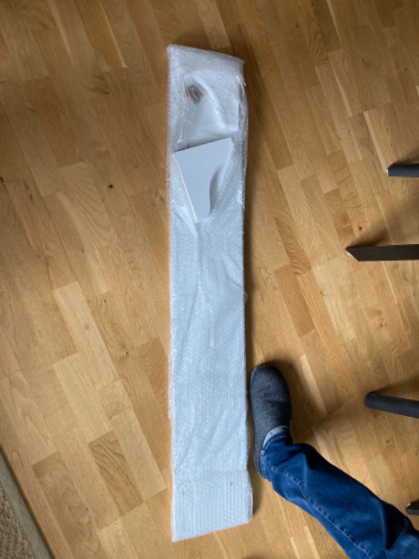 En hylde skal sættes op over en seng. Betonvæg.