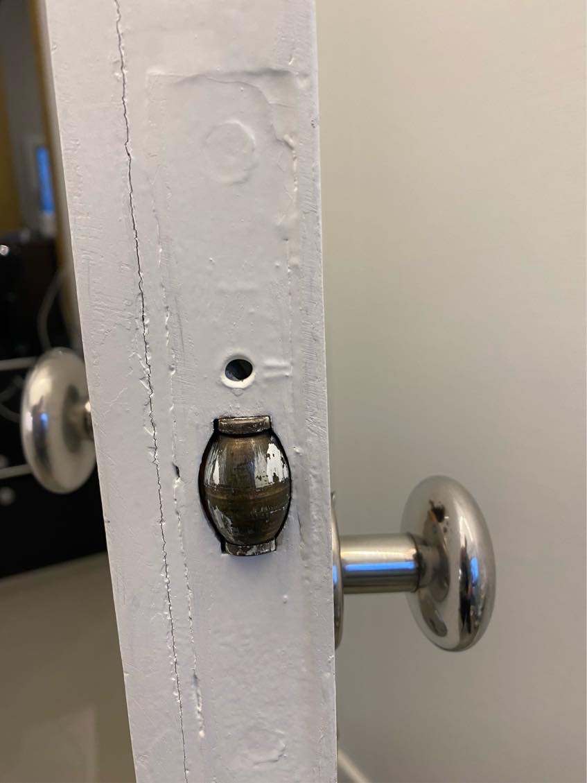 Dørhåndtag på dør samt “lås” på dør