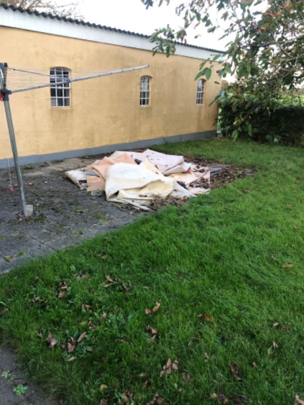 Bunker af affaldstræ og gulvtæpper og ander fra renovering af en 1.sal. Affaldet ligger i haven