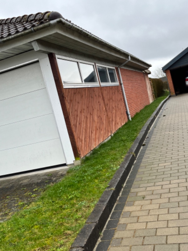 Udgravning af græsplan og anlæggelse af granitskærver langs med husets ene side, hvor der er et smalt bramme af græs