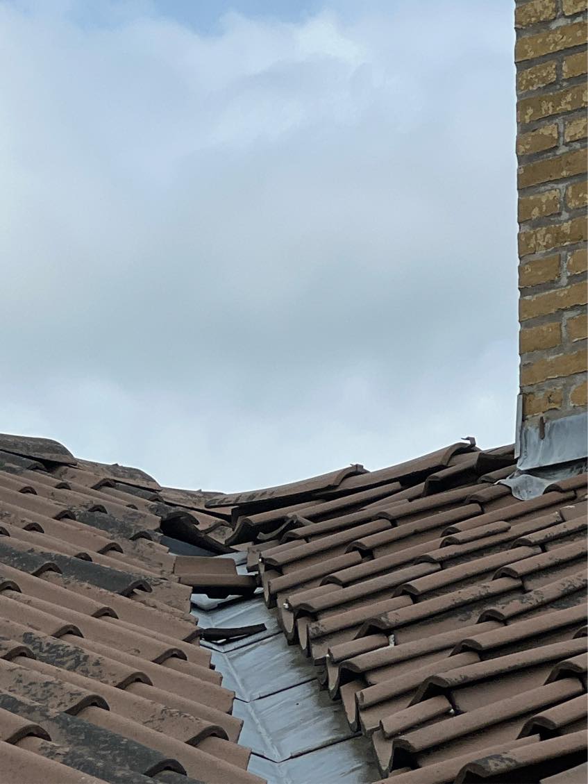 Lægge nye tagsten på et stykke tagryg og omkring skotrende