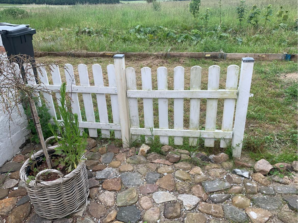 jeg har brug for hjælp til at reparere dette hegn.. det skal skæres til og fastgøres til en pæl, da bygningen har isolation udvendigt..