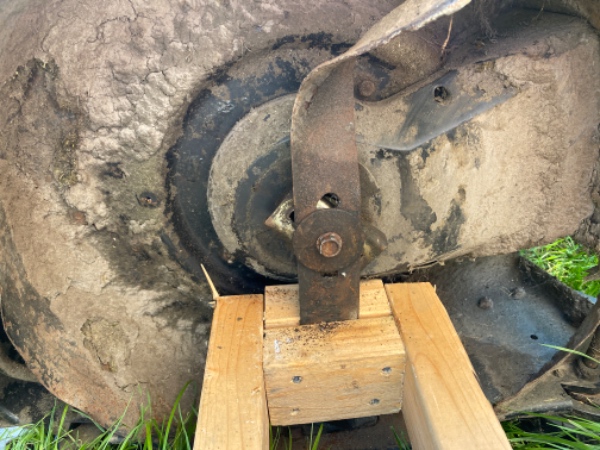 Afmonteret sværdet/klingen på en alm. græsslåmaskine.Bolten er slidt i kanterne og rusten.