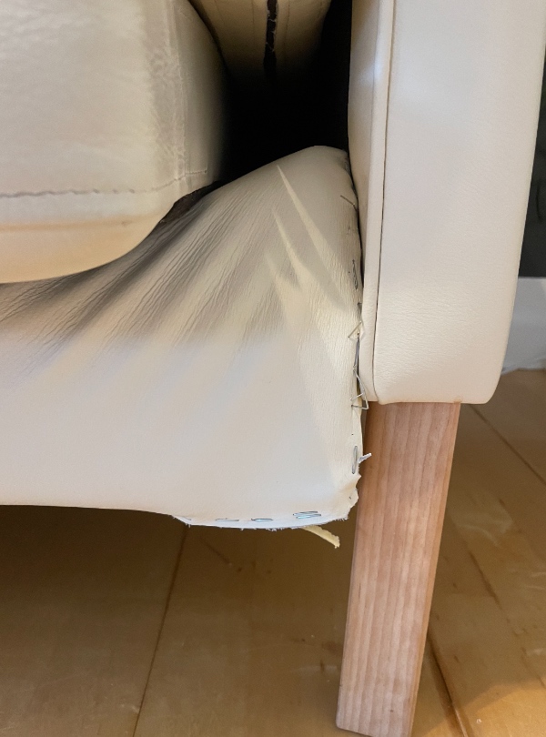 En sofa hvor træet i bunden har givet efter og er gået i stykker